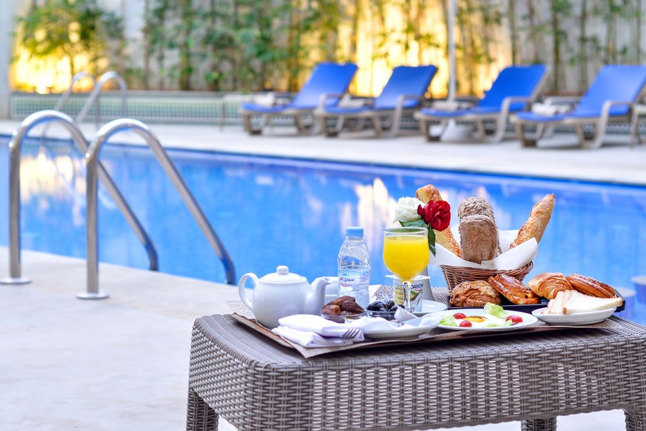 Indulgent breakfast by a poolside with fresh pastries and juice.